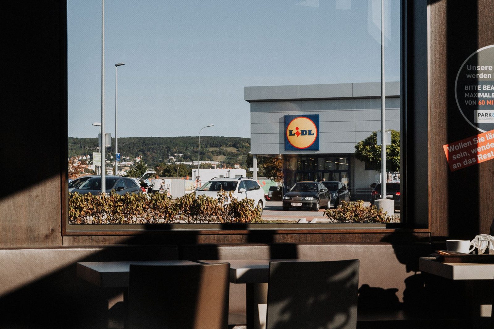 Vista da una finestra su un negozio Lidl e il suo parcheggio pieno di automobili