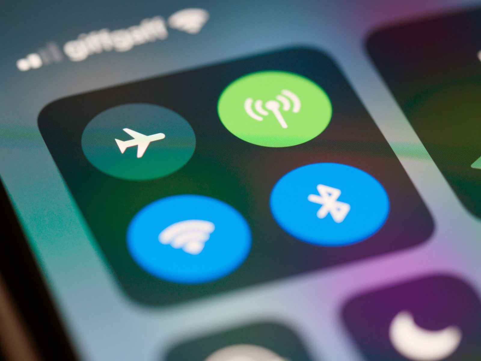 Gros plan sur l'écran d'un smartphone : icônes données mobiles, Wi-Fi, Bluetooth et mode avion