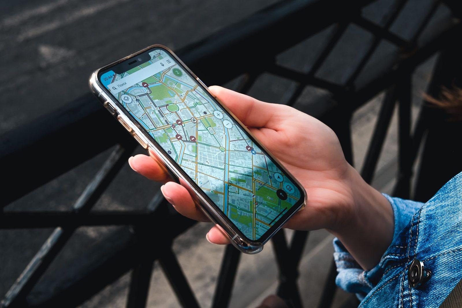 Hand holding a smartphone displaying a city map app outdoors